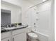 Bathroom featuring granite counters, single sink, toilet, and shower tub combo with white tile surround at 1632 Tropical Palms Circle, Kissimmee, FL 34747