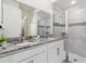 Bright bathroom featuring granite counters, dual sinks, and glass enclosed shower with tile surround at 1632 Tropical Palms Circle, Kissimmee, FL 34747