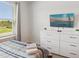 Comfortable bedroom with a flat screen TV, dresser, window, and a bed with blue and grey linens at 1632 Tropical Palms Circle, Kissimmee, FL 34747