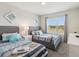 Cozy bedroom with two twin beds, a window with natural light, and stylish decor at 1632 Tropical Palms Circle, Kissimmee, FL 34747