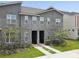 Modern townhome exterior featuring a stone facade, neutral stucco, and well manicured landscaping at 1632 Tropical Palms Circle, Kissimmee, FL 34747