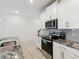 Spacious kitchen featuring white cabinets, stainless steel appliances, and granite countertops at 1632 Tropical Palms Circle, Kissimmee, FL 34747