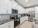 Bright kitchen with stainless steel appliances, granite countertops, and white cabinetry at 1632 Tropical Palms Circle, Kissimmee, FL 34747