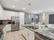 Open concept kitchen with white cabinets, granite counters, stainless steel appliances, and an island at 1632 Tropical Palms Circle, Kissimmee, FL 34747