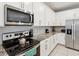 Modern kitchen featuring stainless steel appliances and white cabinets with granite counter tops at 1632 Tropical Palms Circle, Kissimmee, FL 34747