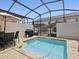 Private screened-in pool area with a BBQ, patio table, and chairs; perfect for outdoor entertaining at 1632 Tropical Palms Circle, Kissimmee, FL 34747