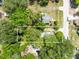 An overhead shot featuring a wooded lot with residential houses, set against a backdrop of quiet neighborhood streets and trees at 1701 E Bay St, Winter Garden, FL 34787
