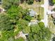 An overhead shot featuring a wooded lot with residential houses, set against a backdrop of quiet neighborhood streets and trees at 1701 E Bay St, Winter Garden, FL 34787