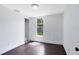 An open, bright bedroom offers hardwood floors and a window with view of a green yard at 1701 E Bay St, Winter Garden, FL 34787