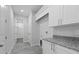 Bright laundry room with granite countertop, cabinets, and view of walk-in closet at 18743 Overton St, Orlando, FL 32833