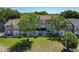 Exterior rear view of condo featuring green lawn and lush mature trees at 2216 Stonington Ave # 2216, Orlando, FL 32817