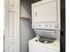 Efficient laundry area featuring a stacked washer and dryer unit with shelf and white door at 2216 Stonington Ave # 2216, Orlando, FL 32817