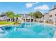 Community pool and lounge area, framed by palms and manicured landscape, with blue skies overhead at 2216 Stonington Ave # 2216, Orlando, FL 32817