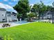 Community pool featuring a lush green lawn, pool furniture and mature shade trees at 2216 Stonington Ave # 2216, Orlando, FL 32817