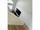 Bright staircase featuring hardwood floors, white walls, and natural light from upper window at 2216 Stonington Ave # 2216, Orlando, FL 32817