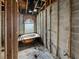 Bathroom under construction with framing, block walls, and a tub under an arched window at 2226 Newt St, Orlando, FL 32837
