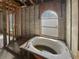 Bathroom under construction with framing, block walls, and a tub under an arched window at 2226 Newt St, Orlando, FL 32837
