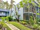 Two-story condo building featuring a screened-in balcony and lush landscaping at 2349 Oak Park Way # 107, Orlando, FL 32822