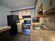 Well-lit kitchen features stainless steel appliances and tile countertops at 2349 Oak Park Way # 107, Orlando, FL 32822