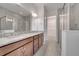 Well-lit bathroom featuring double vanity, granite countertop, and a walk-in glass shower at 2362 Datura Loop, St Cloud, FL 34772