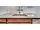 A close view of a stainless steel kitchen sink under a window and set in a granite countertop at 2362 Datura Loop, St Cloud, FL 34772