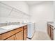 Bright laundry room featuring granite countertops, sink, and storage cabinets at 2362 Datura Loop, St Cloud, FL 34772