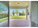 A brick-paved patio, open to a grassy backyard, with view framed by green-painted, covered structure at 2362 Datura Loop, St Cloud, FL 34772