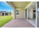 A view of brick-paved outdoor patio with sliding glass doors and grassy yard in the background at 2362 Datura Loop, St Cloud, FL 34772