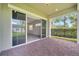 An open, brick-paved patio with sliding glass doors and view of palm trees and fenced backyard at 2362 Datura Loop, St Cloud, FL 34772