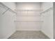 A view into an empty walk-in closet with wire racks for storage and tile flooring at 2362 Datura Loop, St Cloud, FL 34772
