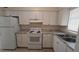 Kitchen featuring white cabinets, granite countertops, and white appliances at 2422 Kingsland Ave, Orlando, FL 32808