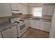 Kitchen featuring white cabinets, granite countertops, and white appliances at 2422 Kingsland Ave, Orlando, FL 32808