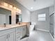 Spa-like bathroom with double vanity, modern soaking tub, and glass-enclosed shower at 2531 Sw 167Th Loop, Ocala, FL 34473