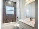 Modern bathroom featuring wood-look wall tiles, a window, and a white vanity at 2531 Sw 167Th Loop, Ocala, FL 34473