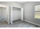 Bedroom with wood-look floors, closet, and abundant natural light at 2531 Sw 167Th Loop, Ocala, FL 34473