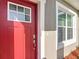 Close-up of a red front door with sidelight windows on a well-maintained house at 2531 Sw 167Th Loop, Ocala, FL 34473