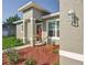 Inviting front entrance with modern stucco accents, colorful landscaping, and stylish outdoor lighting at 2531 Sw 167Th Loop, Ocala, FL 34473
