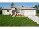 Charming home with a well-manicured lawn and landscaping, a garage, and a red front door at 2531 Sw 167Th Loop, Ocala, FL 34473