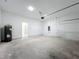 Spacious garage with concrete floor, block walls, hot water heater, and utility door at 2531 Sw 167Th Loop, Ocala, FL 34473