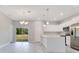 Open layout from Kitchen to Living Room with white cabinets and stainless steel appliances at 2531 Sw 167Th Loop, Ocala, FL 34473