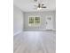 Bright living room featuring modern gray flooring, large windows, and a ceiling fan at 2531 Sw 167Th Loop, Ocala, FL 34473