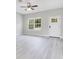 Bright living room featuring modern gray flooring, large windows, and a ceiling fan at 2531 Sw 167Th Loop, Ocala, FL 34473