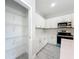 Walk-in pantry with wire shelves and a door leading to a well-equipped kitchen with white cabinets at 2531 Sw 167Th Loop, Ocala, FL 34473