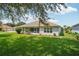 Wide backyard with lush lawn, landscaping along the house and a screened-in lanai, offering serene outdoor living at 26609 Bull Run, Leesburg, FL 34748