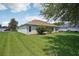Expansive backyard featuring a lush lawn, manicured landscaping, and exterior view of the home with its light-colored exterior at 26609 Bull Run, Leesburg, FL 34748