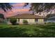Twilight view of the home's backyard featuring a well-manicured lawn, landscaping and an enclosed back patio at 26609 Bull Run, Leesburg, FL 34748