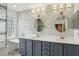 Bathroom featuring double sink vanity, marble tiled walls, and stylish lighting at 26609 Bull Run, Leesburg, FL 34748
