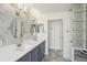 Beautiful primary bathroom featuring double vanity, marble countertops, and decorative glass block accents at 26609 Bull Run, Leesburg, FL 34748