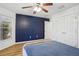 Bedroom featuring wood laminate flooring, a ceiling fan, a closet, and a large double hung windows at 26609 Bull Run, Leesburg, FL 34748