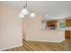Dining area with open kitchen, wood floors, and modern lighting fixture at 26609 Bull Run, Leesburg, FL 34748